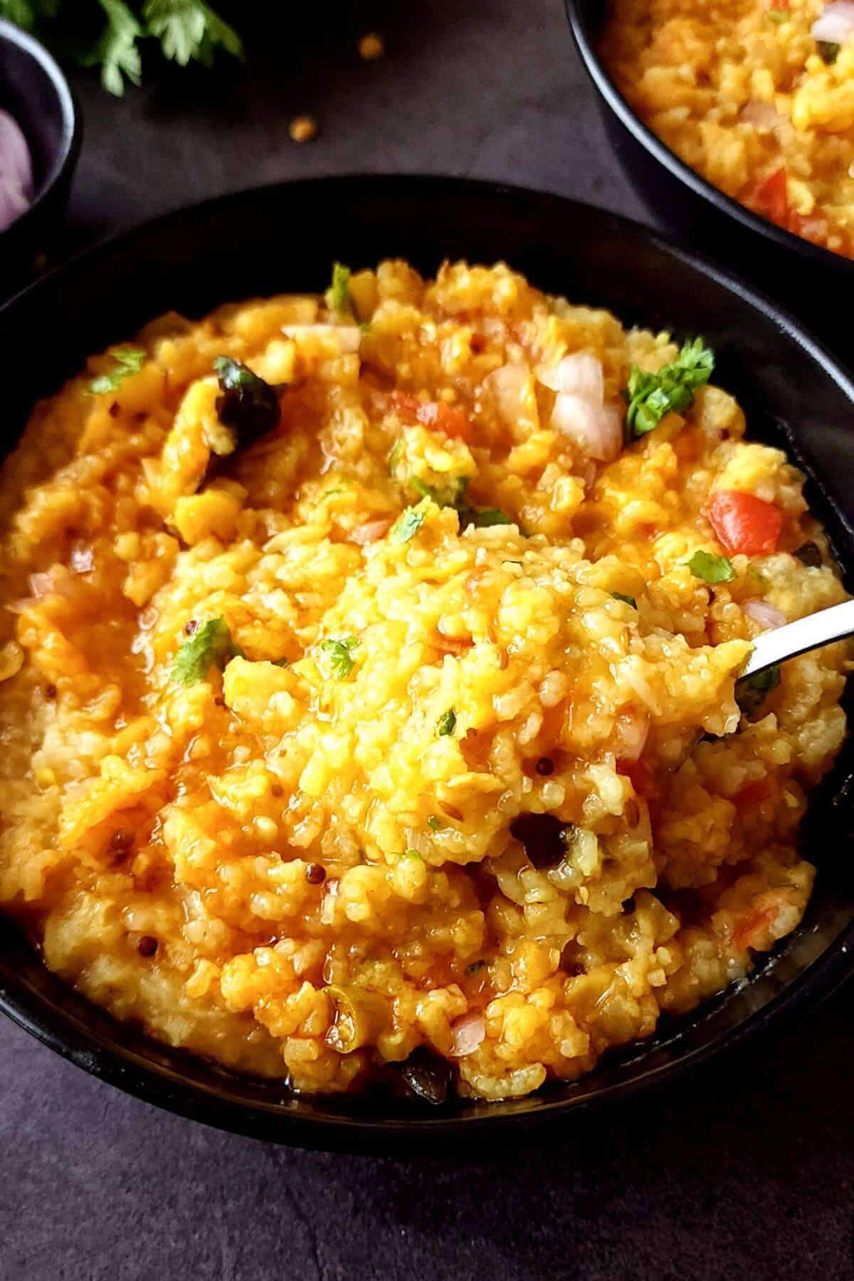 Tuvar dal khichdi in a bowl with a spoon.