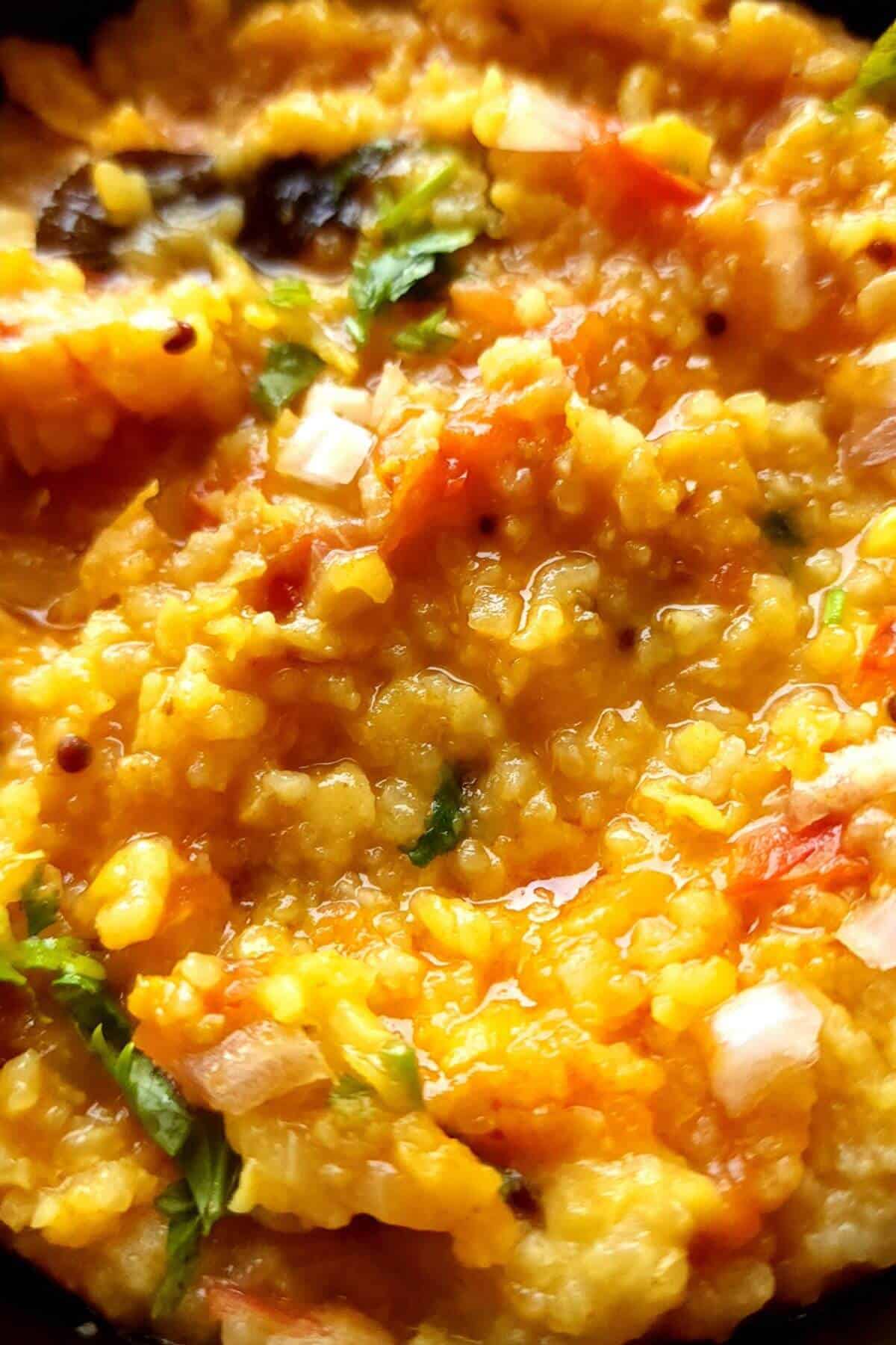 Close up shot of toor dal khichdi with herbs and spices.