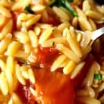 Greek tomato orzo kritharaki garnished with chopped parsley.