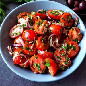 Middle Eastern tomato parsley salad in a grey bowl.