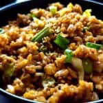 Peanut butter rice with vegetables in a black bowl.