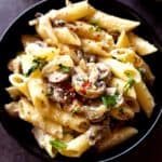 Mushroom ricotta pasta served in a black bowl.