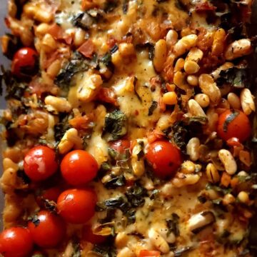 White bean casserole with cherry tomatoes and spinach.