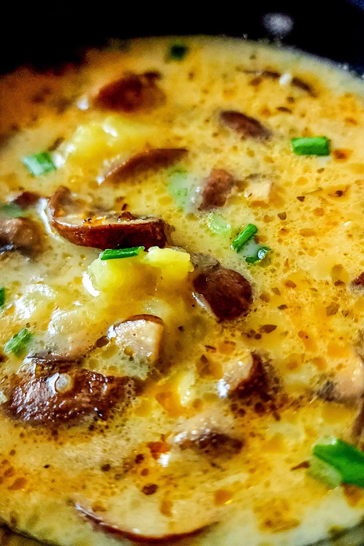 Vegan mushroom potato soup garnished with chopped green onions.