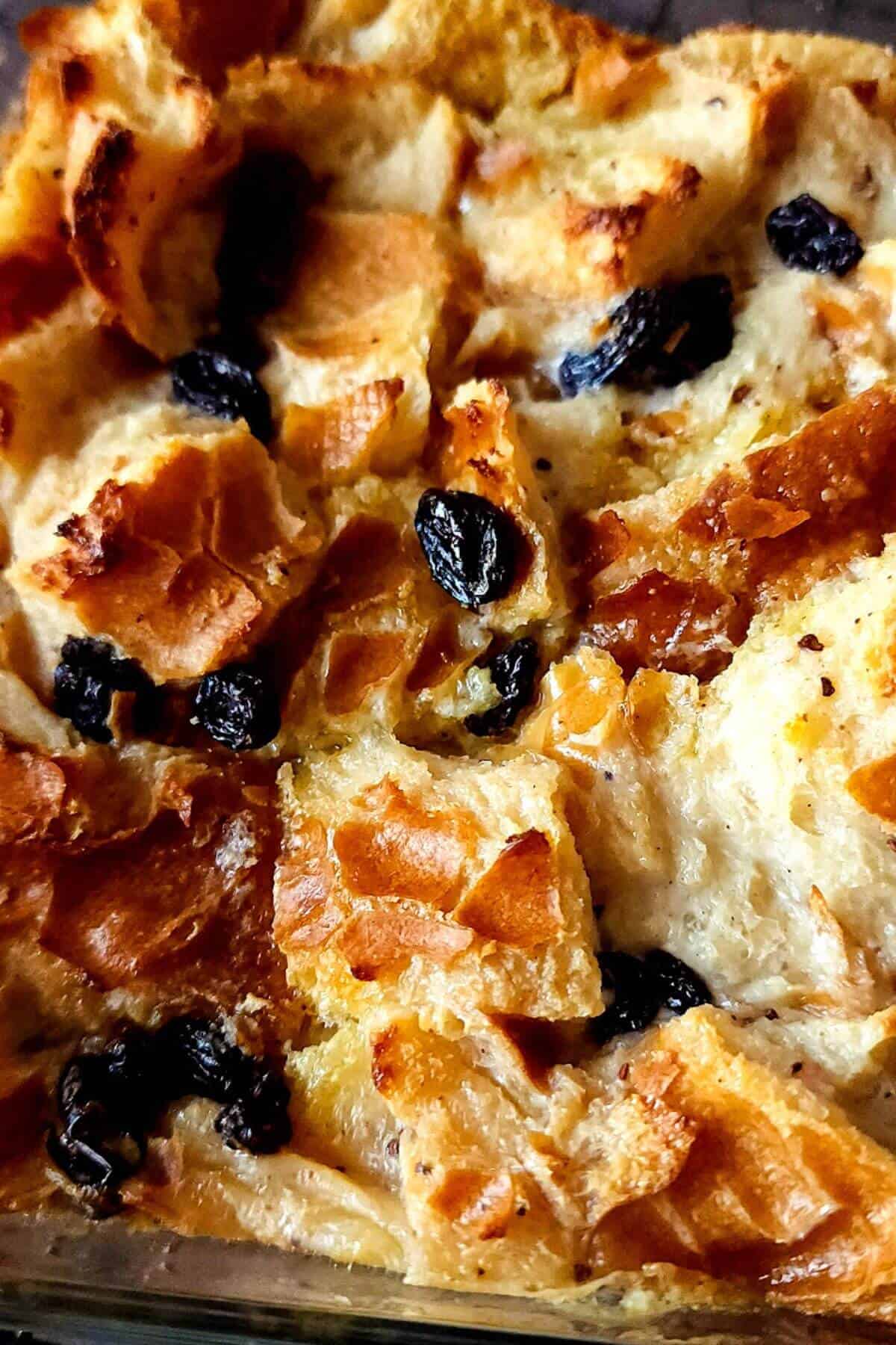 Eggless bread pudding with black raisins in a baking dish.