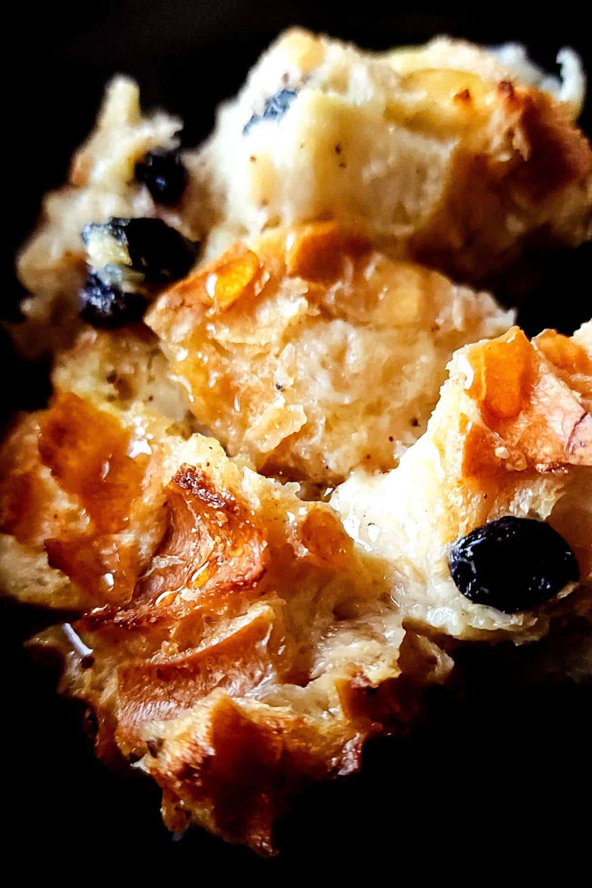 A piece of bread pudding with black raisins.