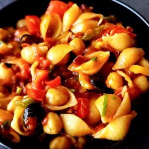 Moroccan pasta with chickpeas in a black bowl.