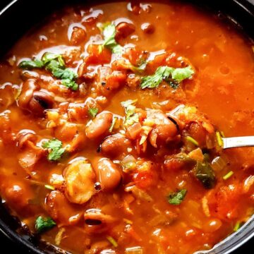 A bowl of fava bean soup with a spoon.