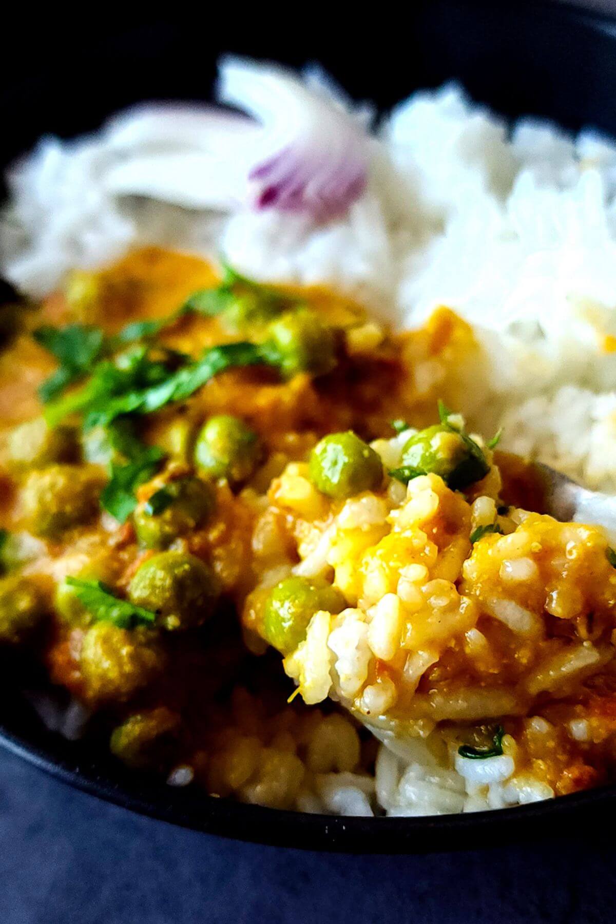 Indian peas curry with rice and onion salad in a bowl.