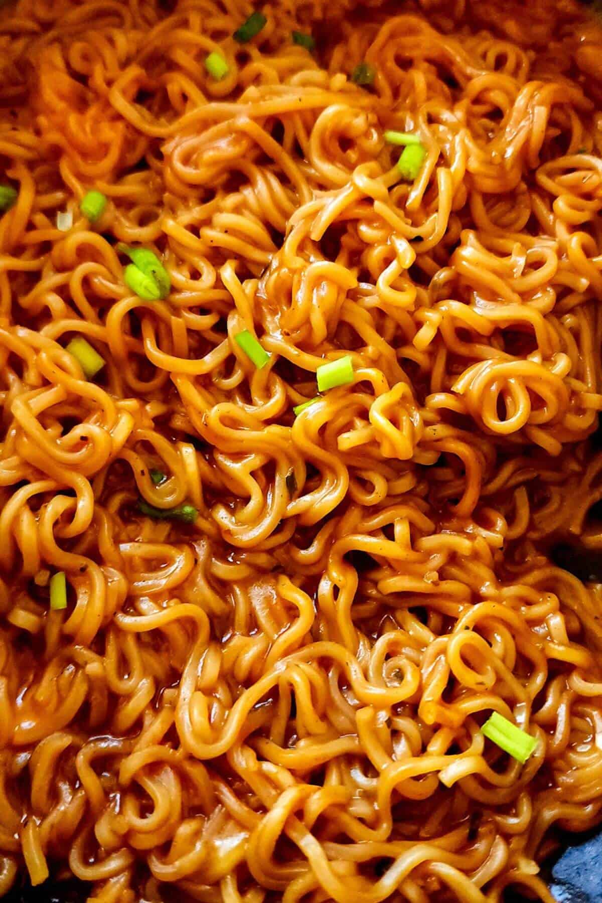 Korean spicy cheddar ramen garnished with chopped green onions.