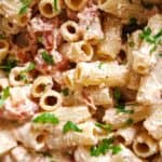 Tomato and ricotta pasta garnished with chopped parsley.