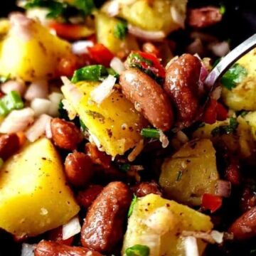 A bowl of Turkish potato and kidney bean salad with a spoon.