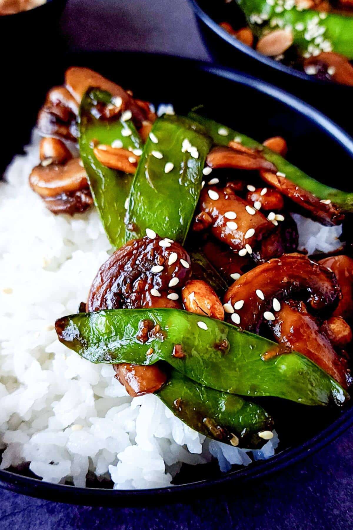 Sauteed mushrooms and snow peas served with rice in a bowl.