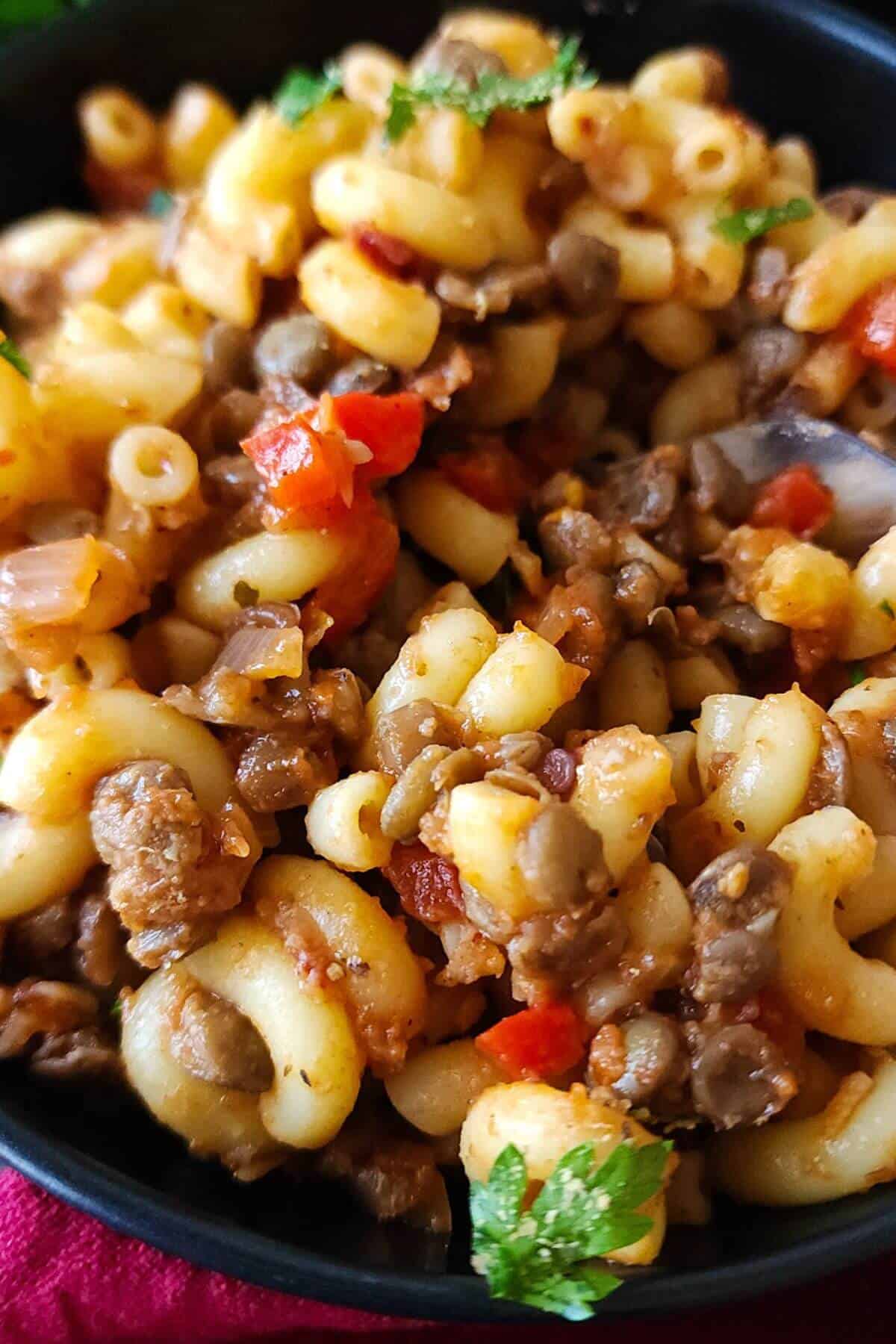 Close up shot of lentils and pasta in a bowl.